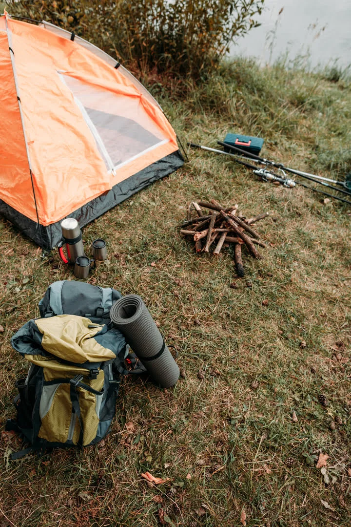 Camping gear arranged neatly beside a tent