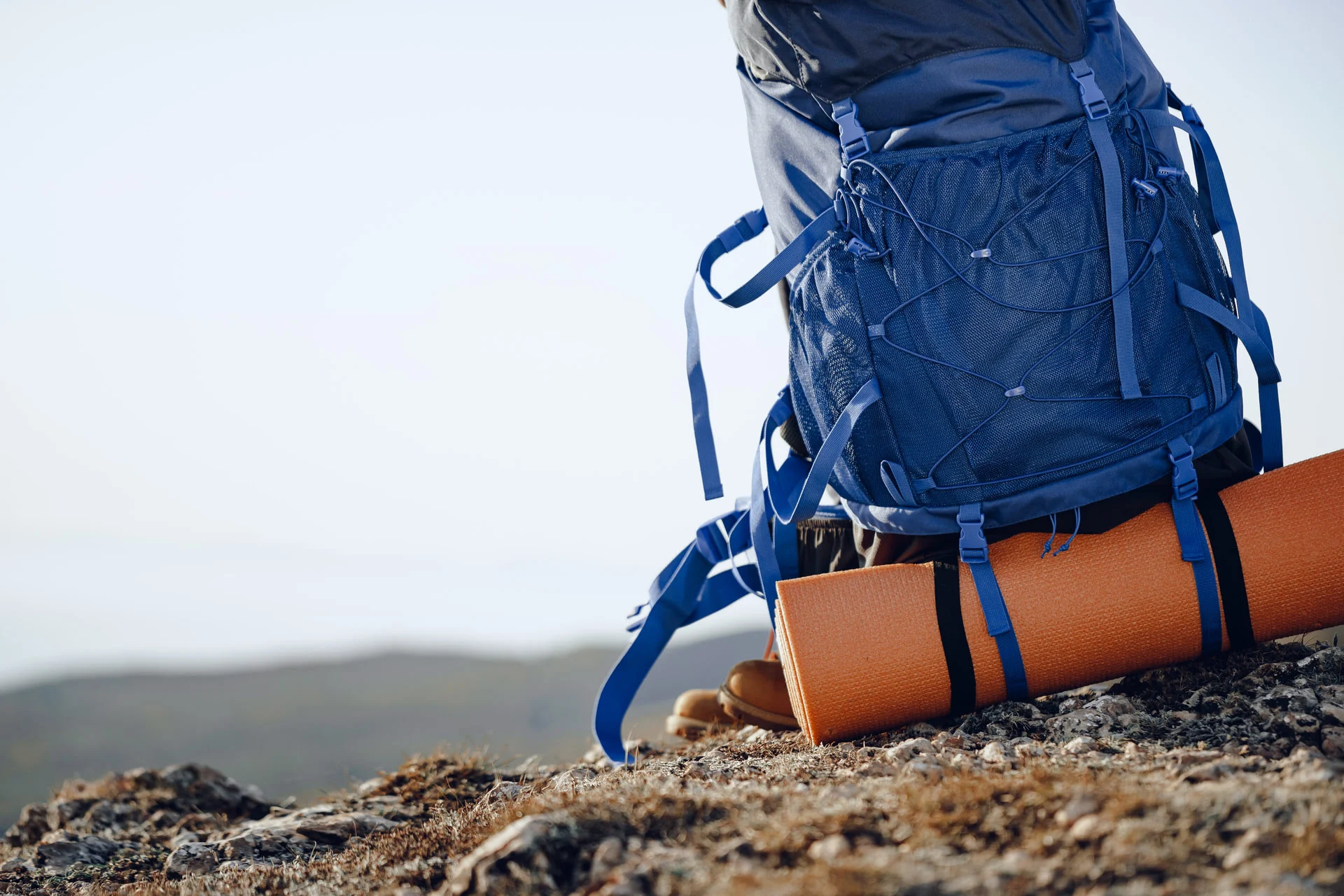 Hiker on a mountain trail overlooking a valley at sunrise